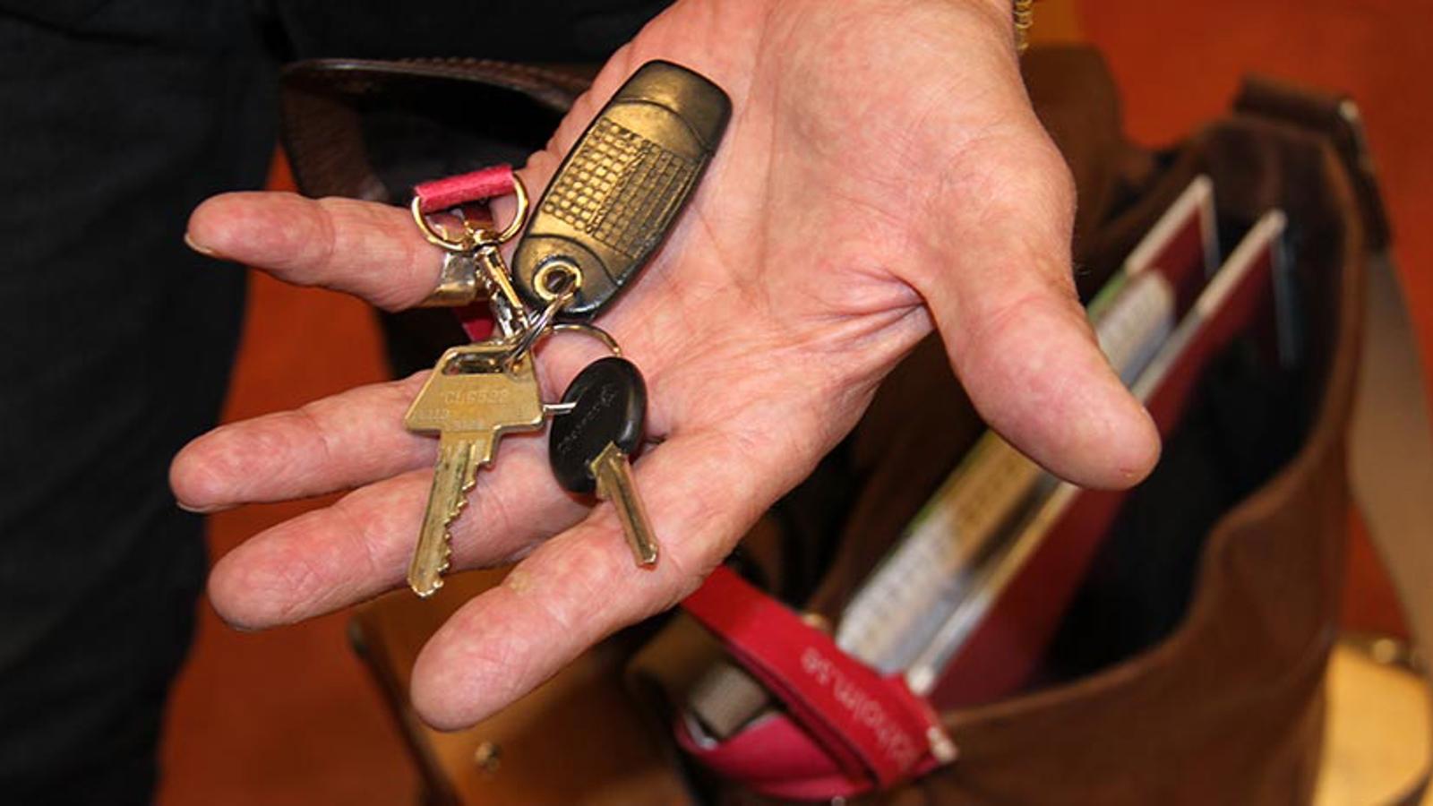 En hand som håller i en nyckelring med flera nycklar på.