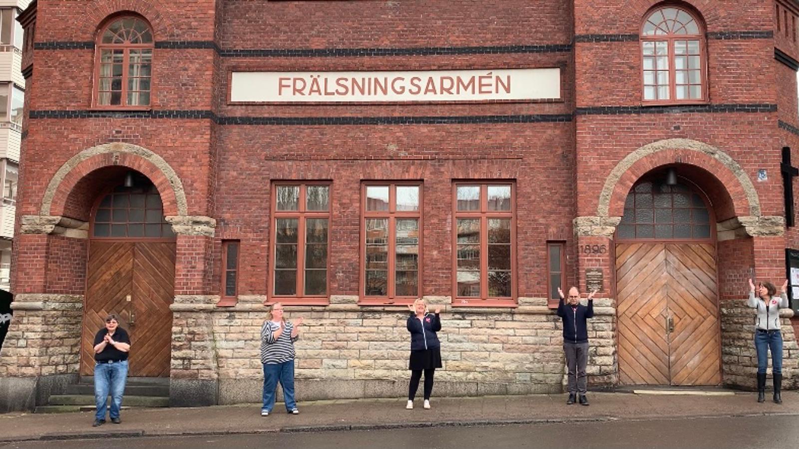 Syntolkning: Exteriörbild av Frälsningsarméns lokal Fästet i Norrköping med dansande personal utanför