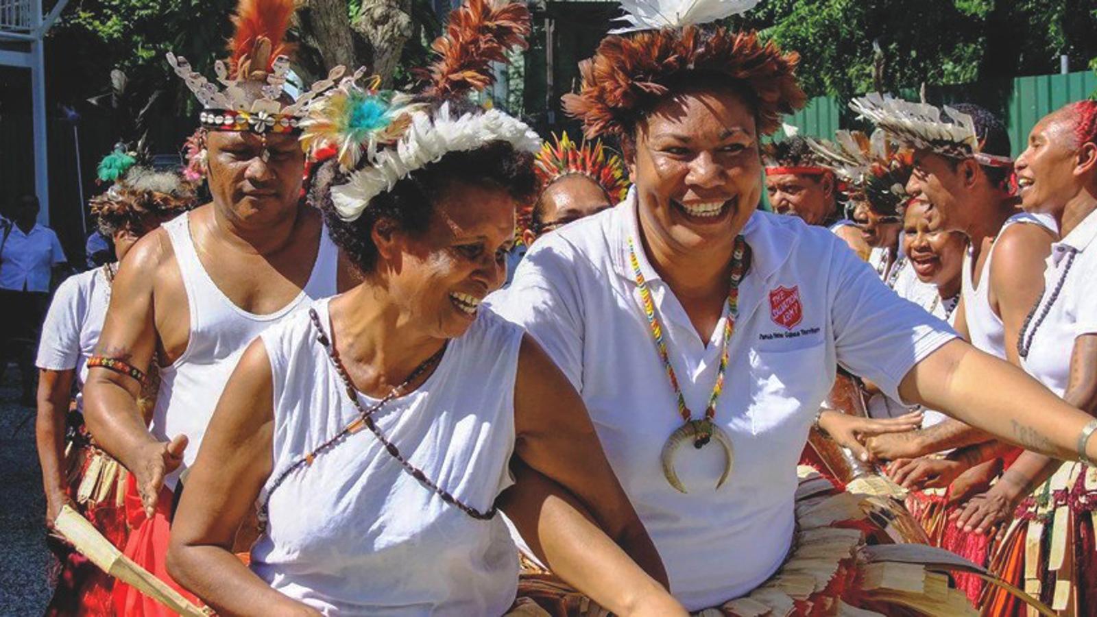 Två glada kvinnor i Papua New Guinea som dansar.