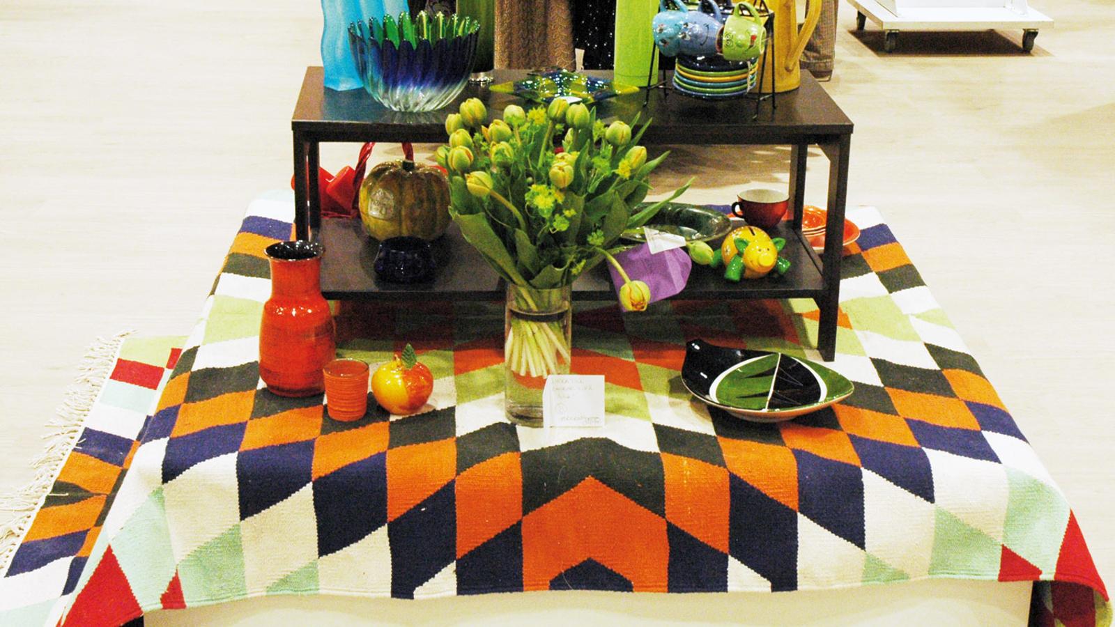Ett litet bord med olika föremål på, bland annat termosar, vaser och dekorationer. 