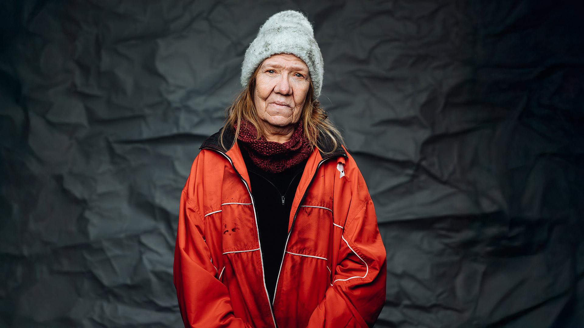 Porträtt på en allvarlig äldre kvinna i slitna ytterkläder