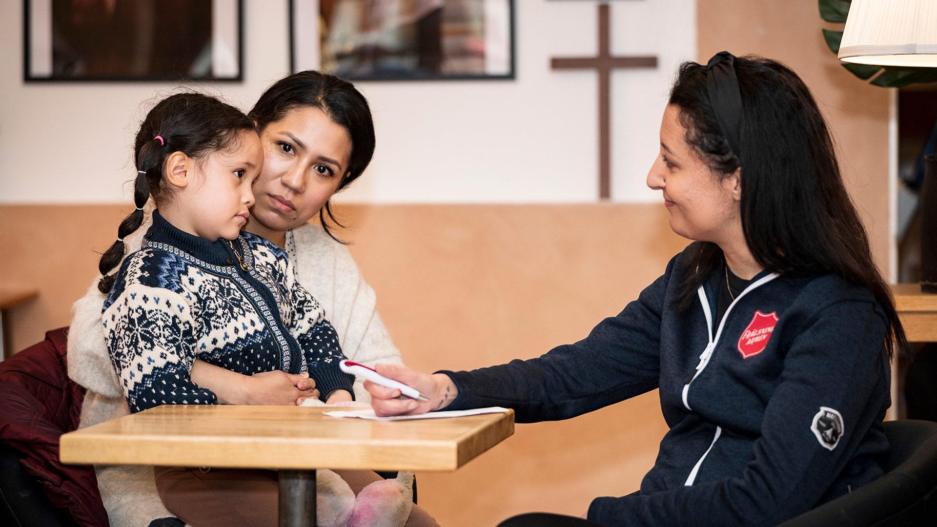 En mamma och dotter träffar en person från Frälsningsarmén