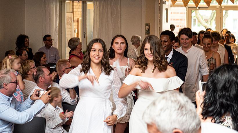 Konfirmander som går på två led.