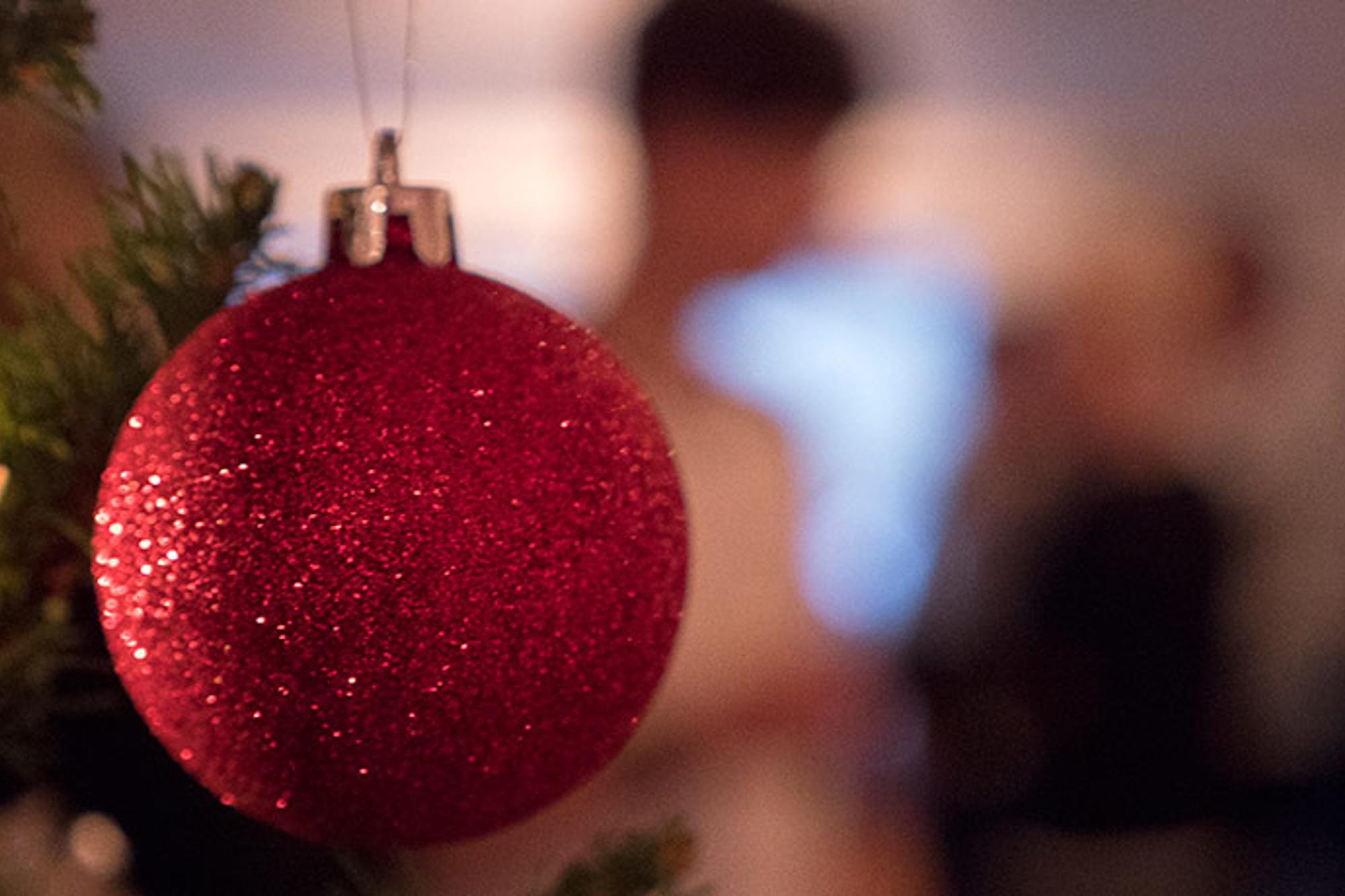 En glittrig julkula som hänger i en gran.