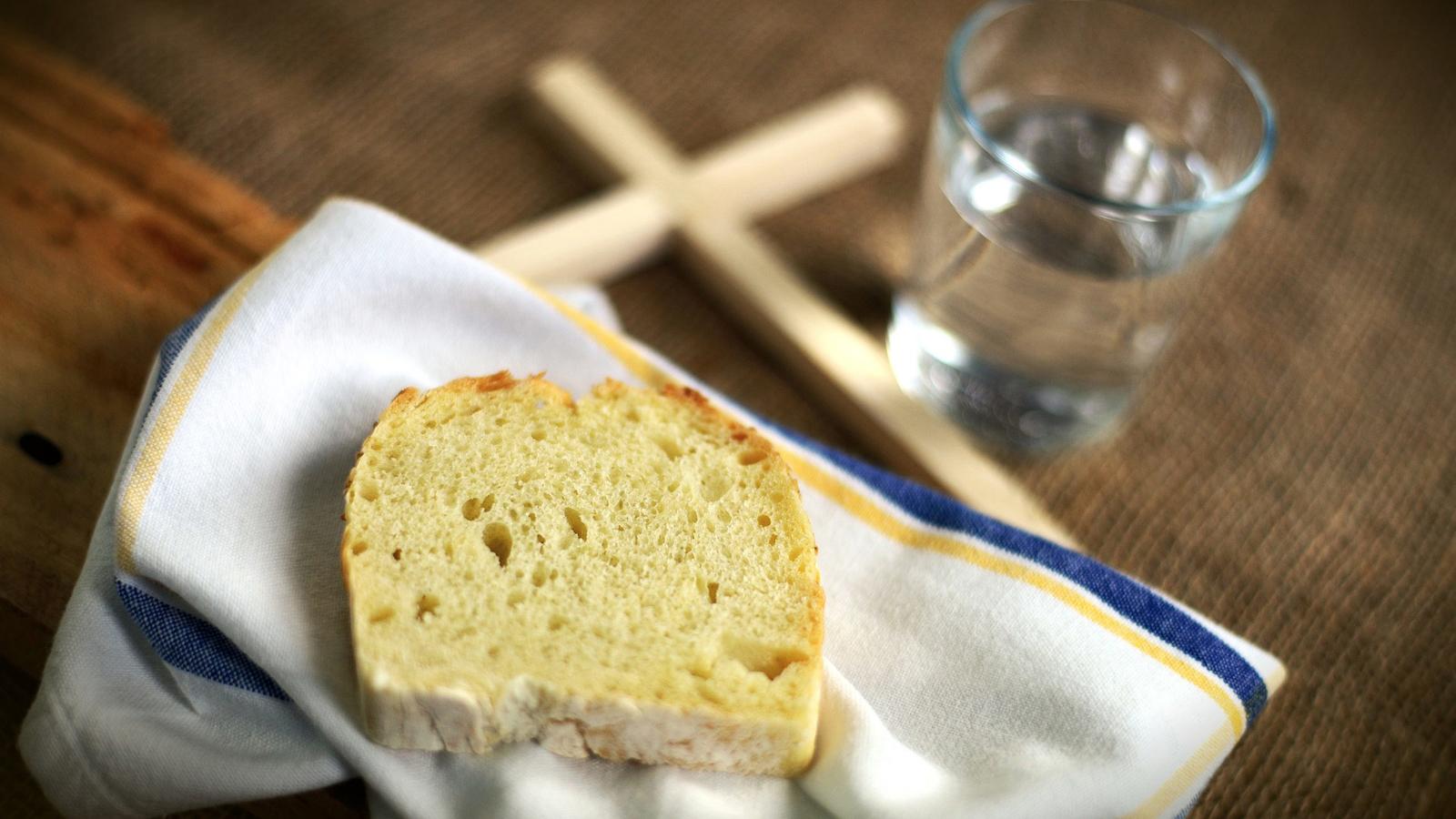 En skiva bröd, ett glas vatten och ett kors