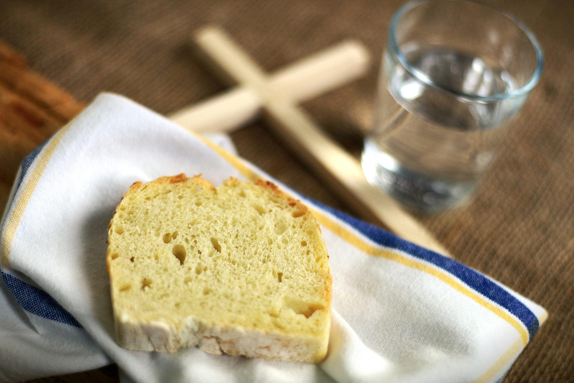 En skiva bröd, ett glas vatten och ett kors