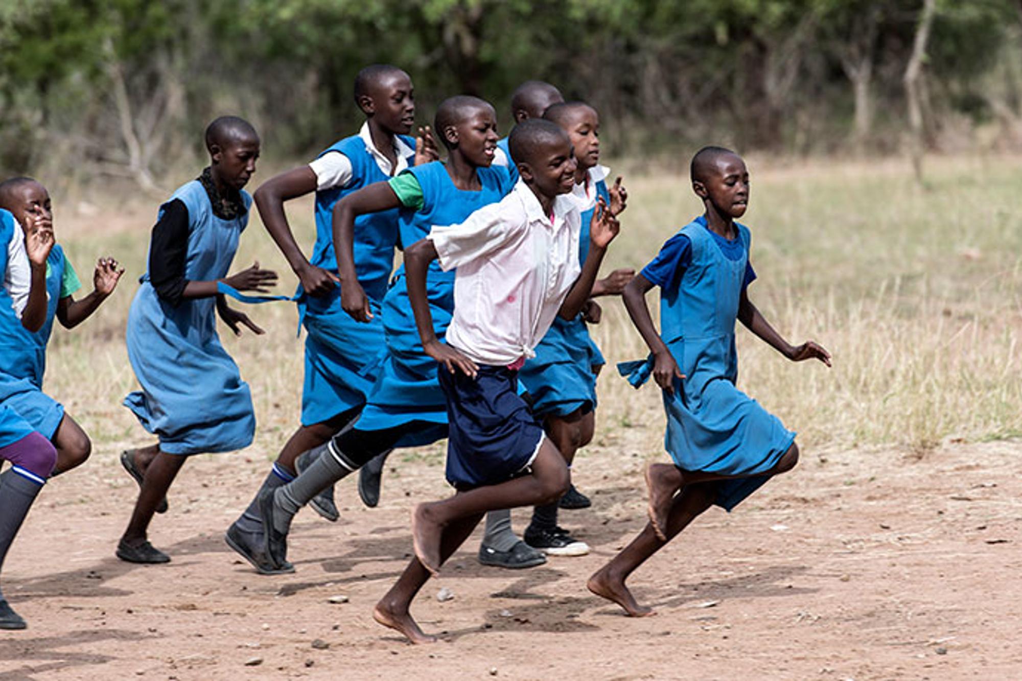 Ett gäng barn i skoluniform som springer.