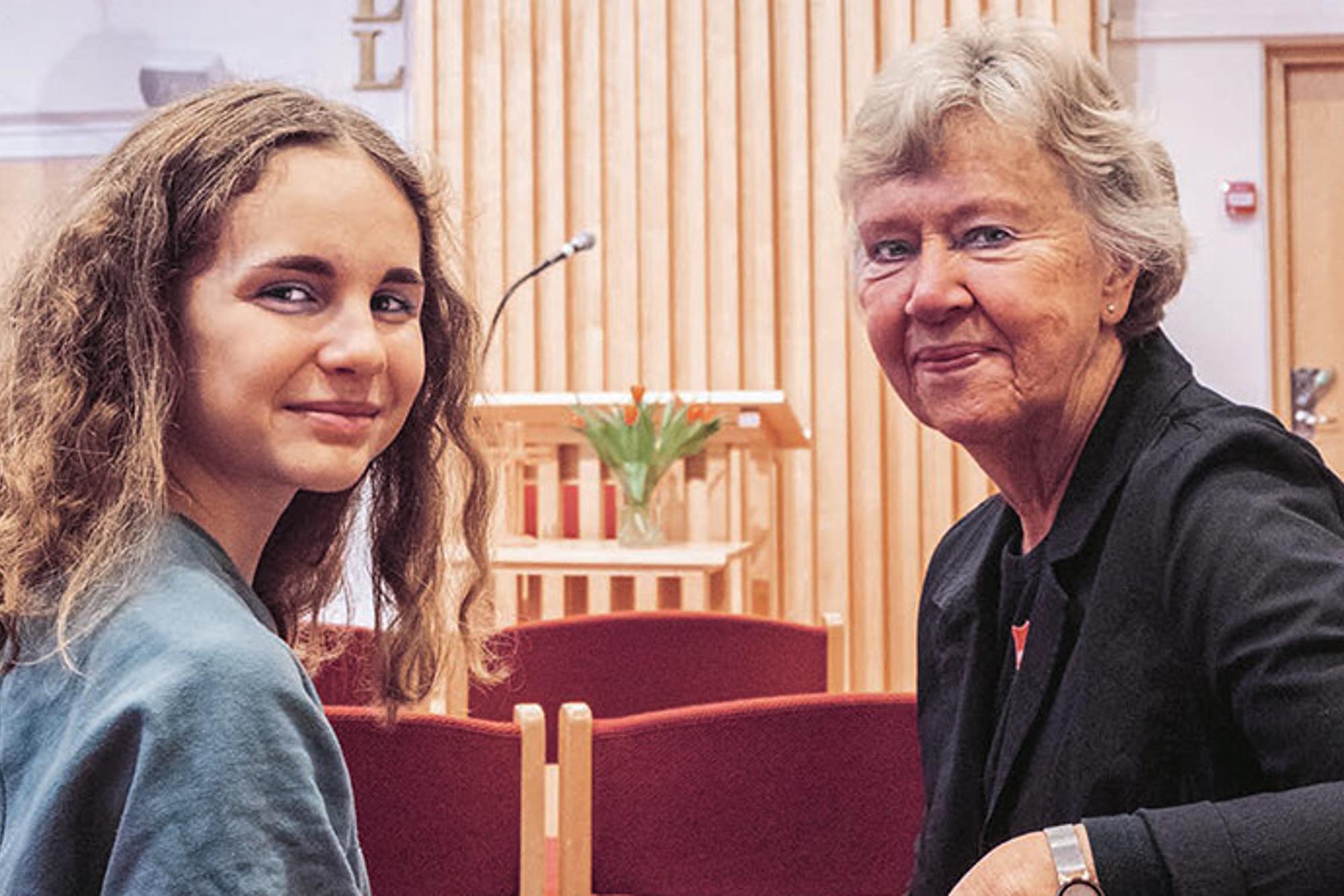 En ung och en äldre kvinna sitter i samlingssalen på en av Frälsningsarméns kårer i Stockholm.