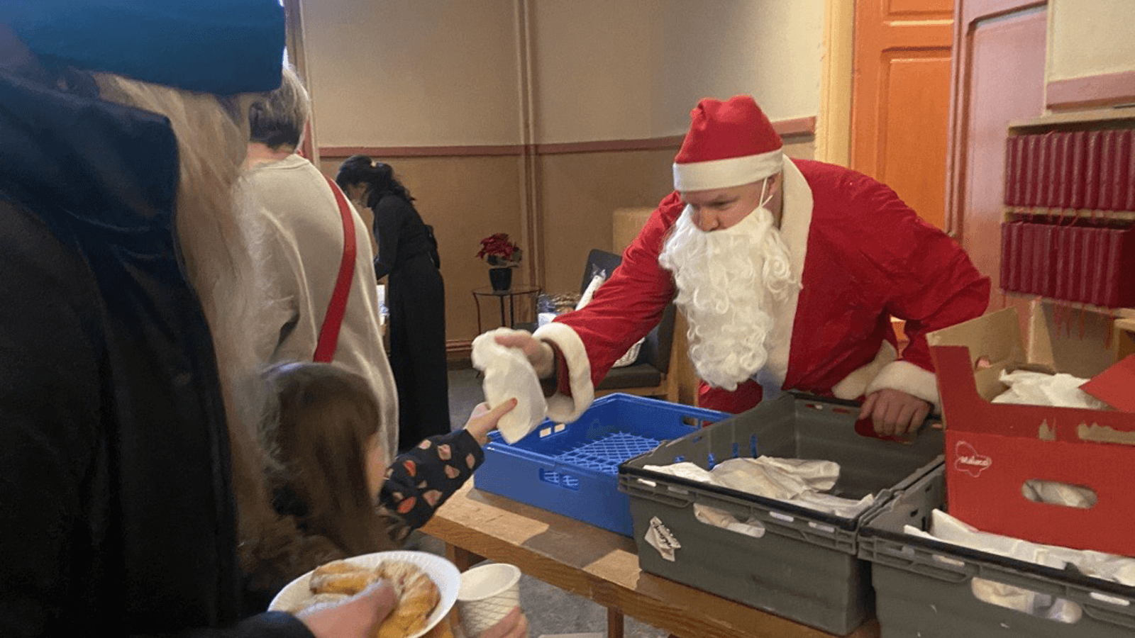 Jultomte som delar ut julklappar till barn på flykt från Ukraina