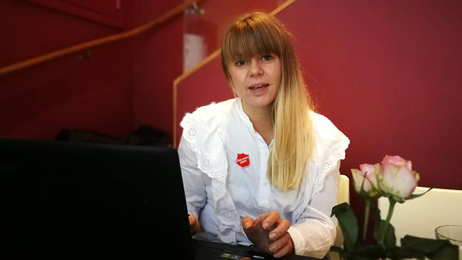 Fanny Ljungholm som är verksamhetsledare för ett omsorgs- och rehabiliterande arbete i Visby. Hon sitter vid en dator och tittar upp in i kameran.