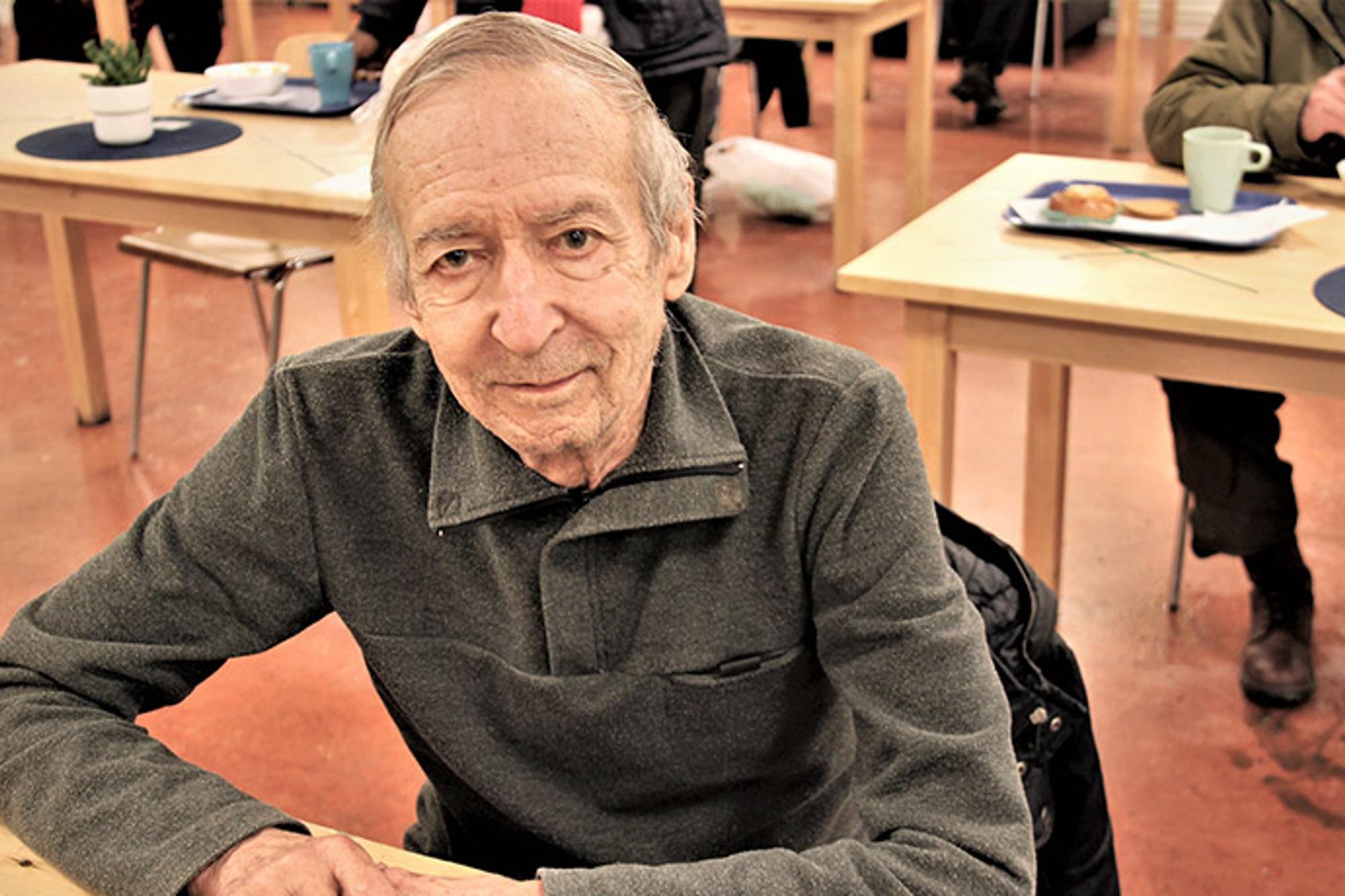 En äldre man, Bertil, som sitter vid ett bord på Sociala centret. Han tittar in i kameran.