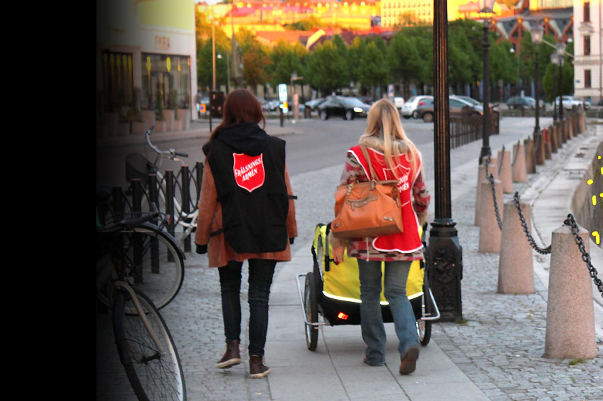Ryggtavlorna på två kvinnor från Frälsningsarmén som går vid hamnen i Göteborg.