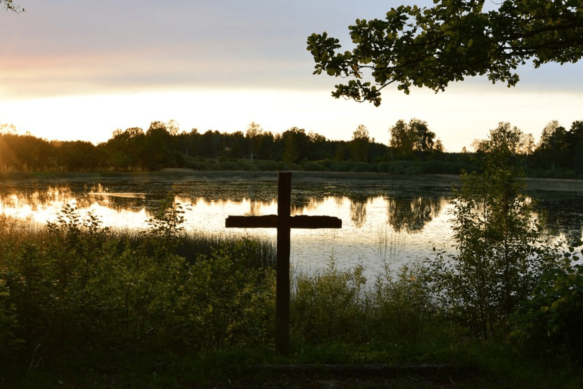 Ett fint kors i naturmiljö med vatten i bakgrunden
