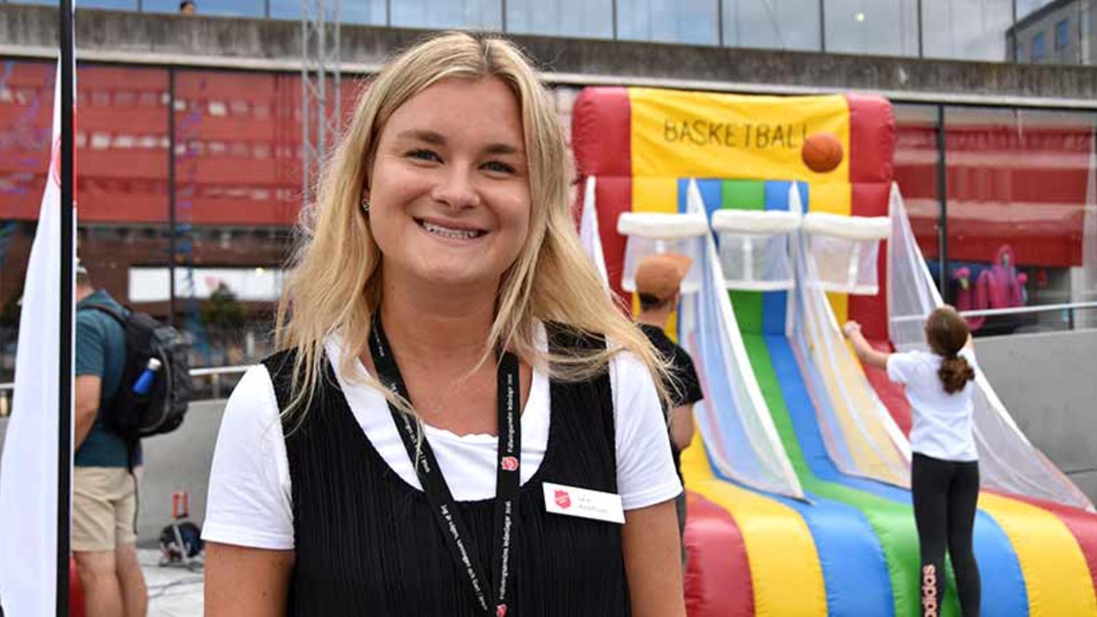 Julia Adolfsson som är nationell barnkonsulent på Frälsningsarmén. Hon står utomhus vid en basketboll-aktivitet.