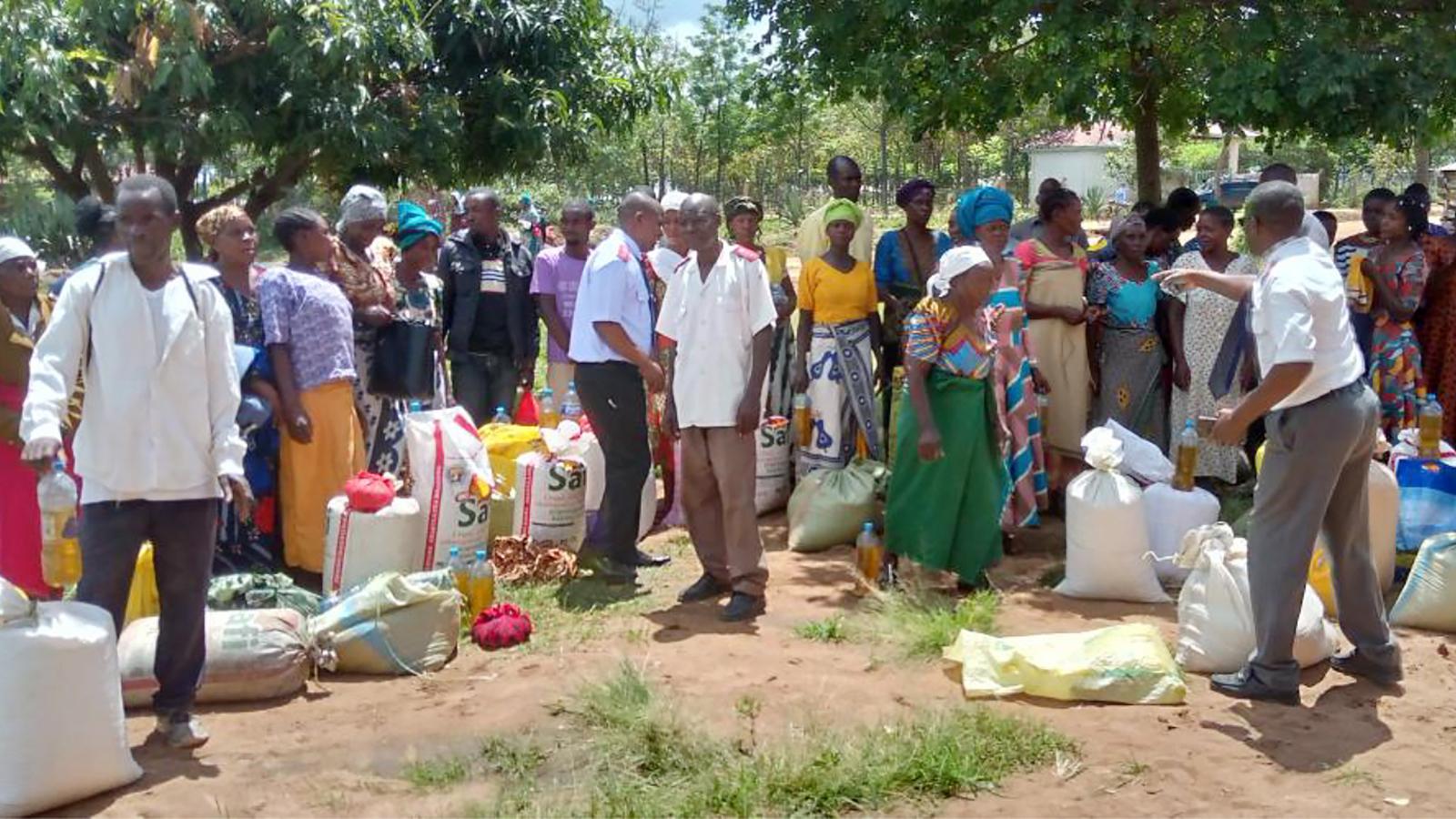 Frälsningsarméns personal i Tanzania delar ut mat från säckar till en grupp människor.
