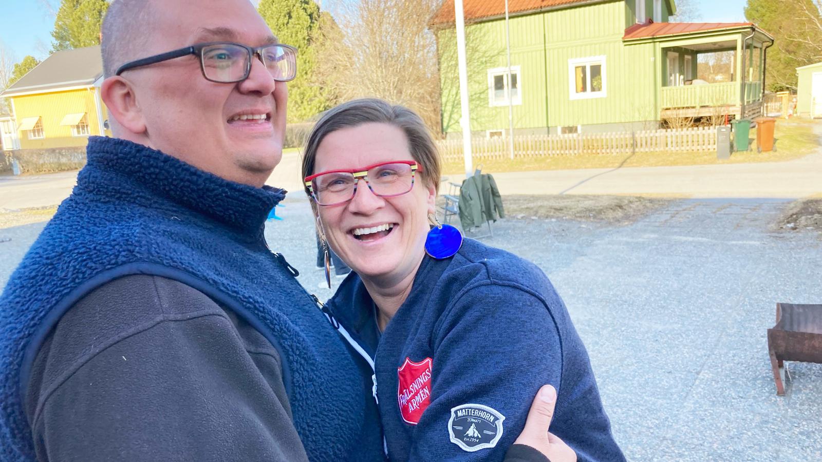 Daniel och Monika Lovén håller skrattande om varandra i solen utanför kåren i Skellefteå.