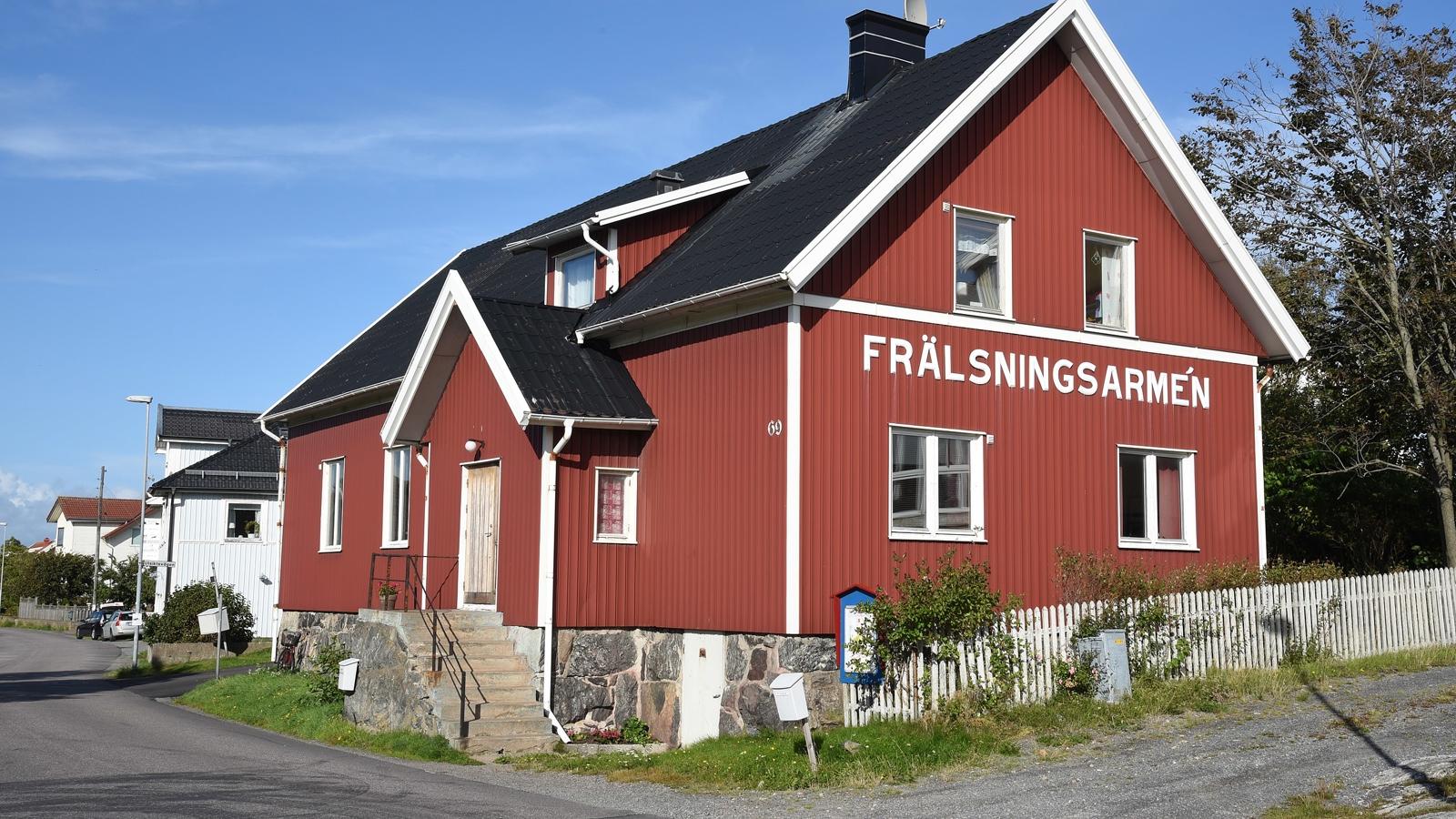 En röd villa i två våningar med namnet Frälsningsarmén i stora bokstäver på gaveln.