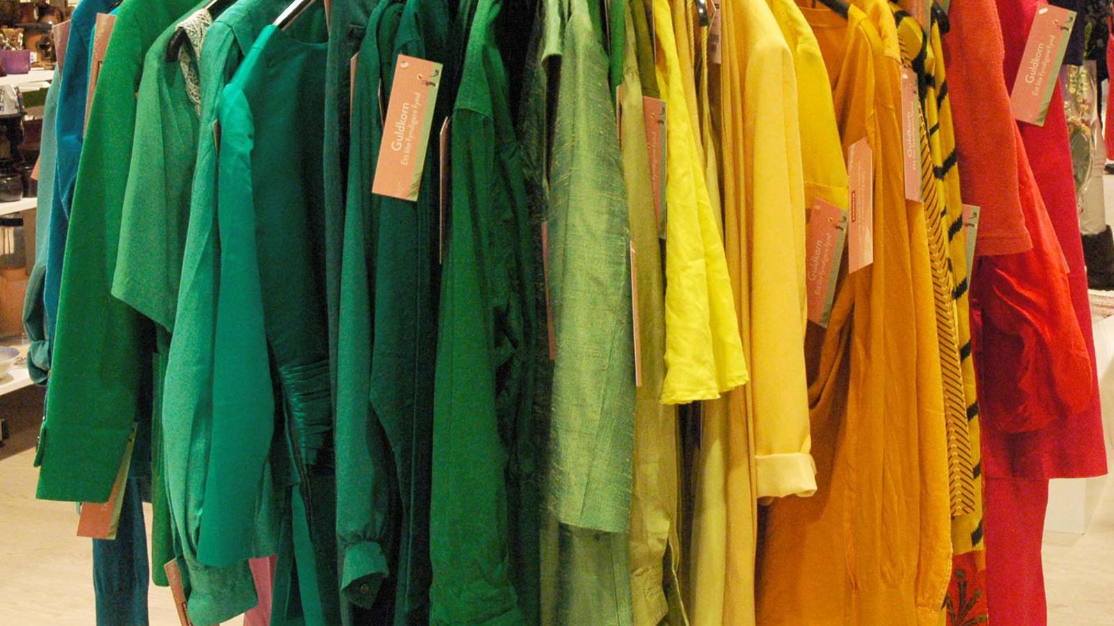 Röda, orangea, gula och gröna kläder som hänger på galgar.