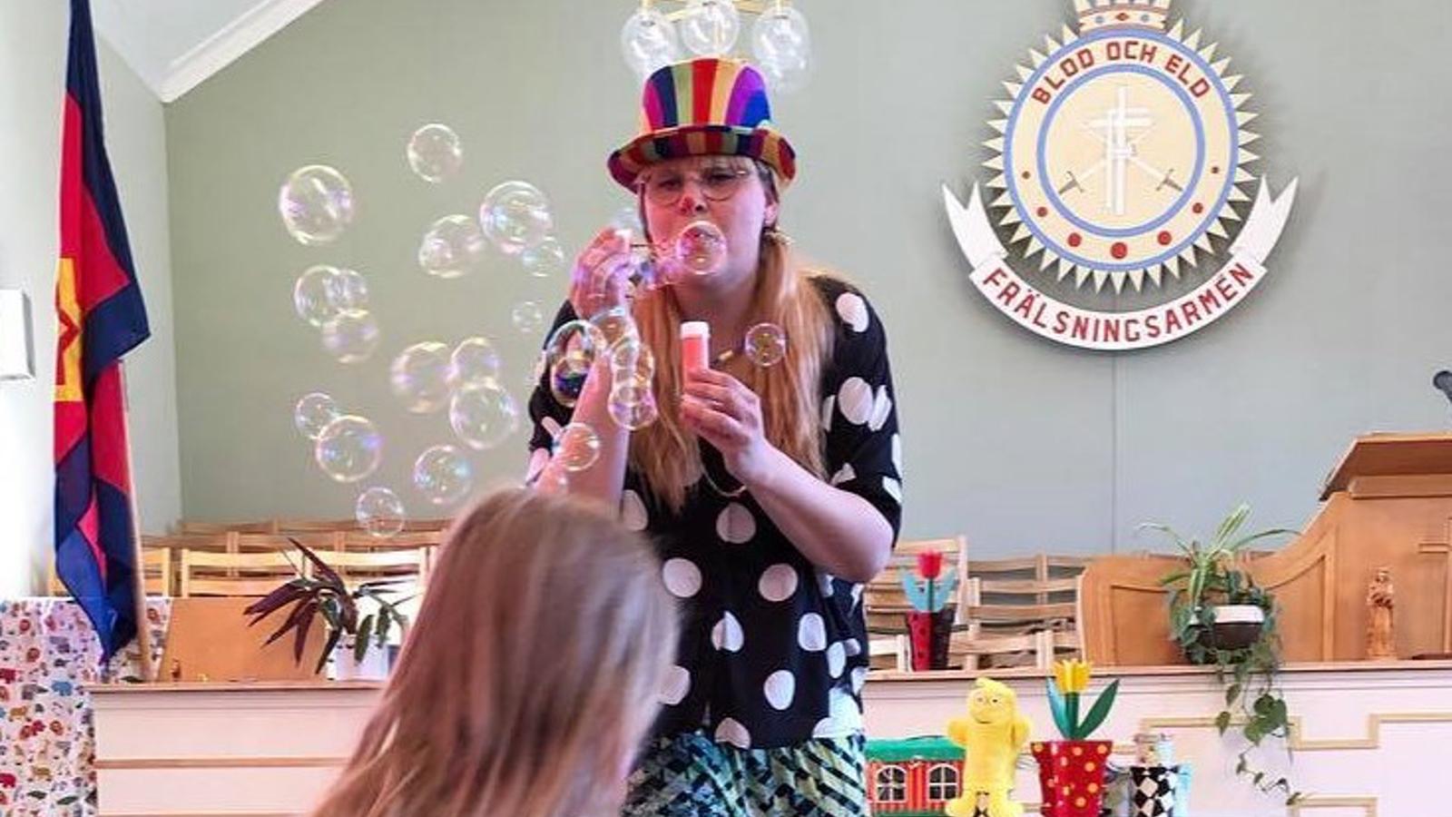 Clown blåser bubblor på barn