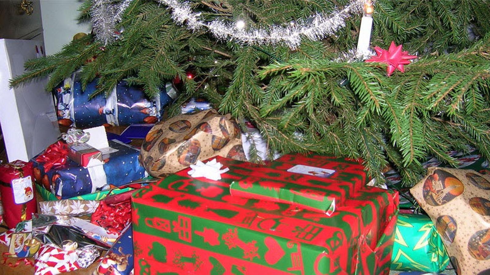 En hög av inslagna julklappar som ligger under en julgran.