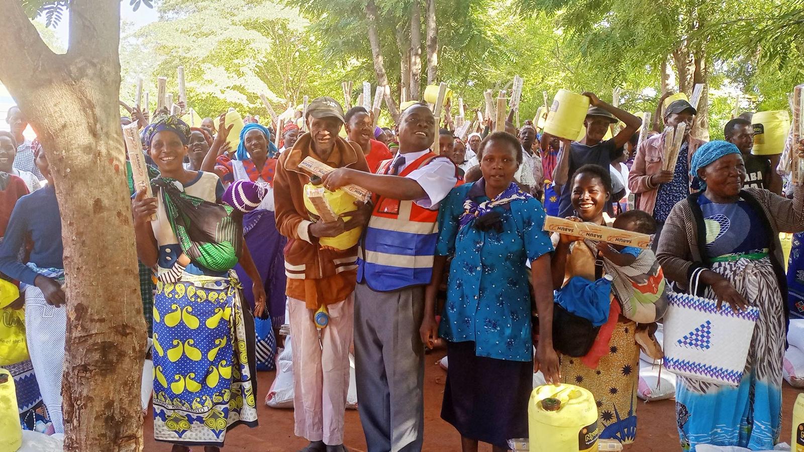 Familjer i Kenya som håller i dunkar som de ska fylla vatten i.