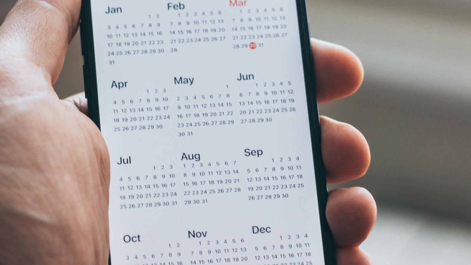 En mobiltelefon med en kalenderapp som är öppen.