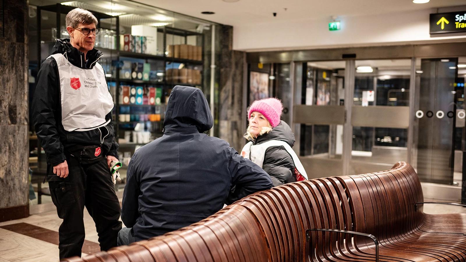 Jenny Alm och Mikael Swärd samtalar med en person inne på Stockholms central.